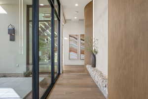 Hall featuring light wood finished floors and recessed lighting