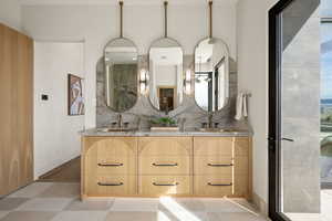 Full bath with double vanity, a shower, and backsplash