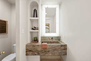 Bathroom featuring built in shelves and vanity