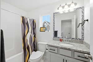 Bathroom with vanity and shower / tub combo with curtain