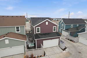 View of front of property with a residential view, concrete driveway, and a shingled roof