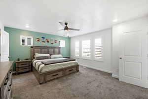 Carpeted bedroom with baseboards and ceiling fan