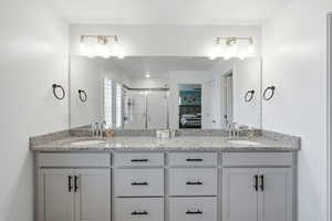 Ensuite bathroom featuring double vanity and a shower stall