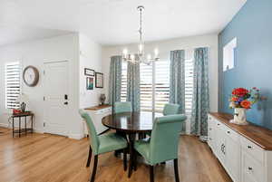 Dining space featuring suspended lighting and light wood-style flooring