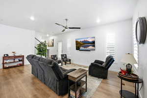 Living room with light wood-style floors, a ceiling fan, healthy amount of natural light, and recessed lighting