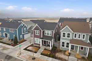 Traditional-style house featuring driveway, a residential view, a garage, and roof with shingles