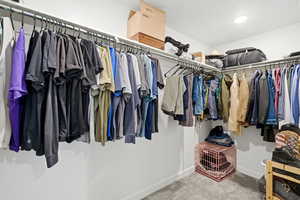 Walk in closet with carpet flooring