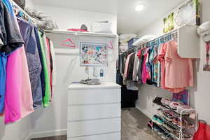 Walk in closet featuring dark colored carpet