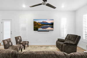 Living room with a ceiling fan, light wood finished floors, plenty of natural light, and recessed lighting
