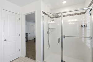 Bathroom featuring light carpet, a stall shower, and light tile patterned floors
