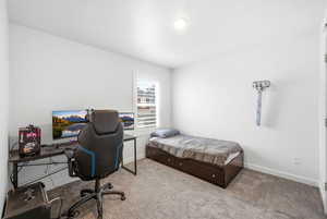 Bedroom featuring a desk, carpet floors, and a textured ceiling