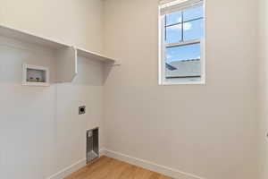 Laundry room with light wood-style floors, washer hookup, and electric dryer hookup