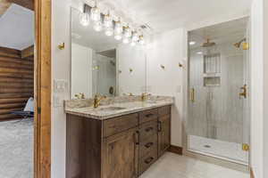 Bathroom with a stall shower, double vanity, and log walls