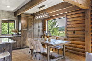 Dining space featuring light wood-style floors and beamed ceiling