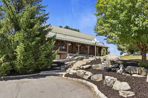View of front facade with a metal roof and stairway