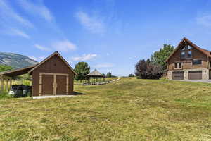 View of grassy yard featuring a gazebo, a storage unit, and a mountain view