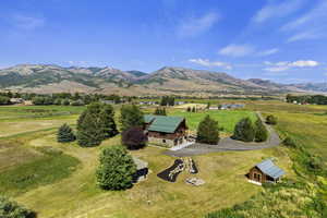 Aerial view of sparsely populated area with a mountainous background and agricultural land
