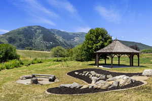 View of community with a mountain view, a patio area, a fire pit, and a gazebo