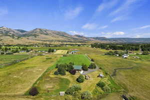 Aerial view of sparsely populated area featuring a mountainous background and agricultural land