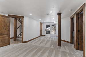 Unfurnished living room featuring light carpet and recessed lighting