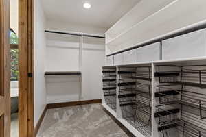 Walk in closet with light colored carpet