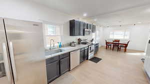 Kitchen featuring stainless steel appliances, light stone counters, light wood-style flooring, and recessed lighting