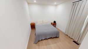 Bedroom with wood finished floors and recessed lighting