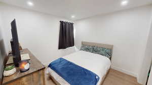 Bedroom with wood finished floors and recessed lighting