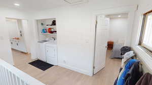 Laundry area featuring light wood finished floors, recessed lighting, and washer and clothes dryer