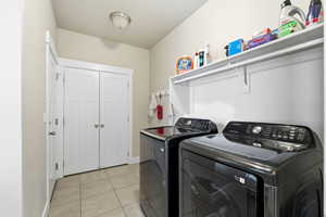Laundry room with light tile patterned floors and separate washer and dryer
