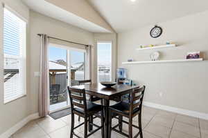 Dining space featuring vaulted ceiling and light tile patterned flooring