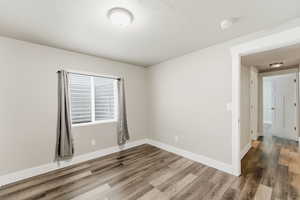 Empty room with wood finished floors and a smoke detector