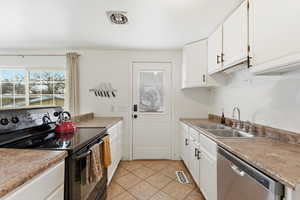 Kitchen featuring electric range, white cabinets, dishwasher, and light tile patterned floors