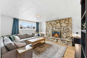 Living room featuring a stone fireplace and wood finished floors