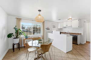 Dining space with light tile patterned flooring and baseboards