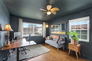 Home office with ceiling fan and wood finished floors