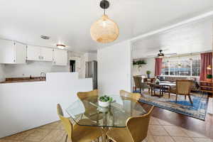 Dining space with a ceiling fan and light tile patterned flooring