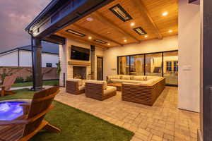 Patio terrace at dusk with a patio and an outdoor living space with a fireplace