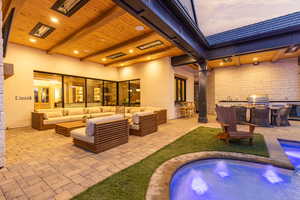 View of patio / terrace with outdoor furniture, area for grilling, and a hot tub
