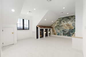 Bonus room featuring vaulted ceiling, recessed lighting, and light colored carpet