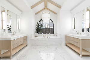 Full bath with a bath, two vanities, suspended lighting, beamed ceiling, and light marble finish floors