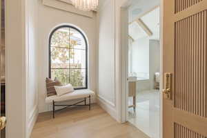 Living area with suspended lighting and light wood-style flooring