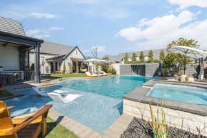 View of pool with patio surround, an in-ground hot tub, and a fenced backyard
