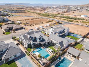 Aerial perspective of suburban area featuring a mountainous background and a pool