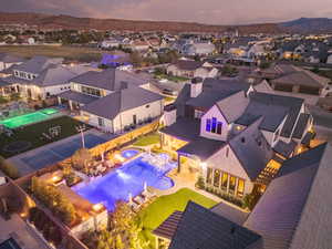 Aerial view at dusk of view of pool area, a residential view, and a mountain view