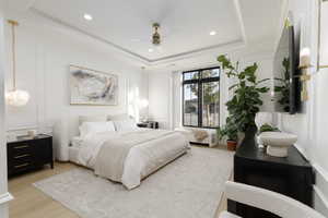 Bedroom featuring a decorative wall, light wood-style flooring, ceiling fan, recessed lighting, and ornamental molding