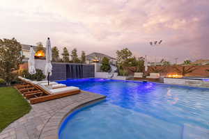 View of swimming pool featuring a fenced backyard, patio surround, and a water slide