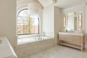 Bathroom with vanity, a garden tub, light marble finish floors, and vaulted ceiling