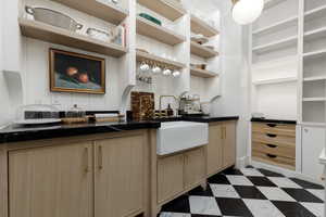Kitchen featuring dark countertops, dark flooring, and light wood finish cabinetry