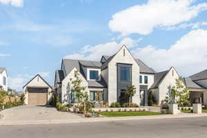 French country home featuring stone siding, an outbuilding, and driveway